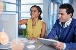 Two  colleagues discussing using covalence on a computer and tablet