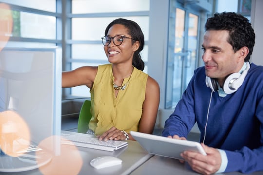 Two  colleagues discussing using covalence on a computer and tablet